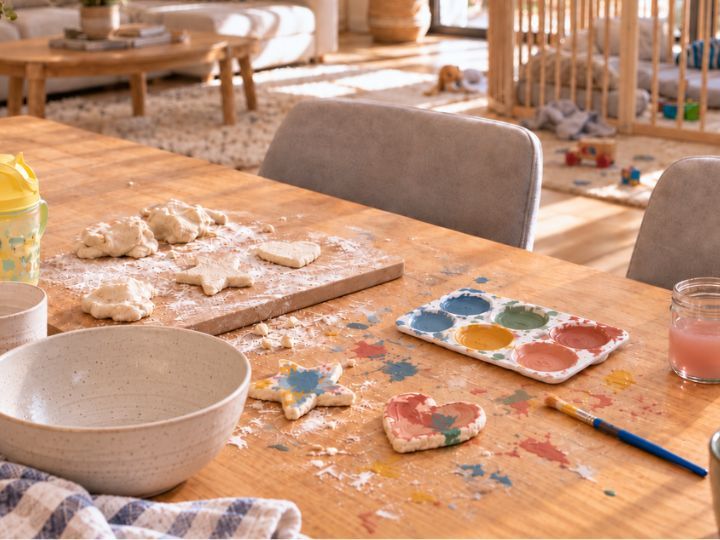 Une table couverte de pâte à sel, de farine et de peinture, à ranger après.